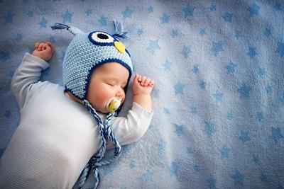 Sleeping newborn baby on bed.