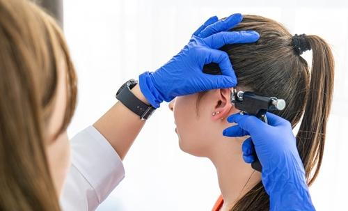 Young girl getting her ear pierced