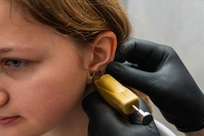 Young girl having an ear piercing on clinic