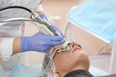 Woman-in-process-of-laser-treatment-with-the-doctor-in-blue-gloves.
