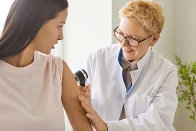 Skin specialist examining female client for skin concerns