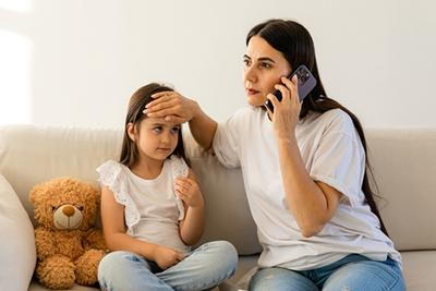 Concerned mom making a phone call to pediatrician for her ill child