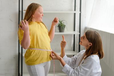 Doctor praising a child for progress in weight management