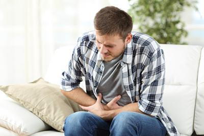 Man with visible discomfort from stomach ache or bloating