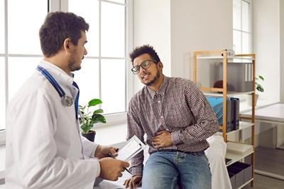 Doctor talking to a patient with abdominal pain on clinic