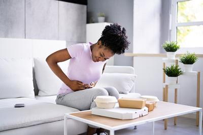 Woman with stomach ache after eating a meal