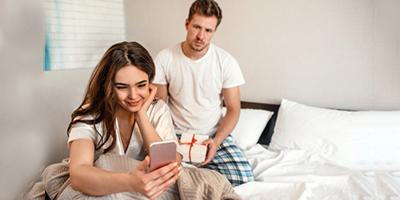 Woman socializing on smartphone while partner seeks attention
