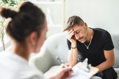 Therapist talking to a man on sofa