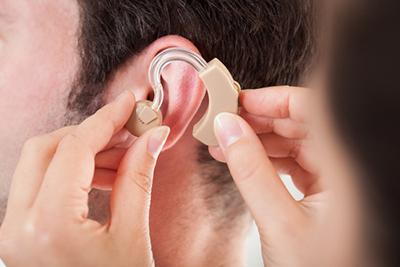 Doctor put some hearing aid in patient