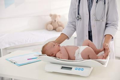 Newborn-Screening-Procedure-Pediatrician-Weighs-Baby