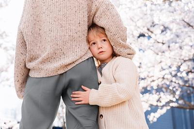 Child struggling with anxiety clings tightly to parent