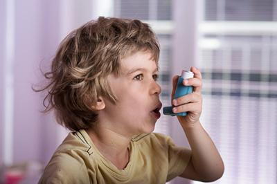 Young boy suffering from Asthma with inhaler