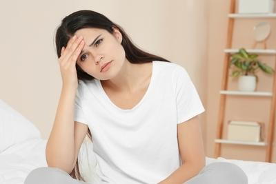 Woman with headache likely from hormonal changes