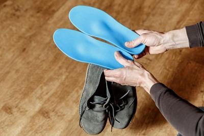 Custom foot orthotics hold by a person