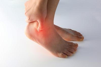 Man experiencing severe pain in Achilles tendon area after physical activity.