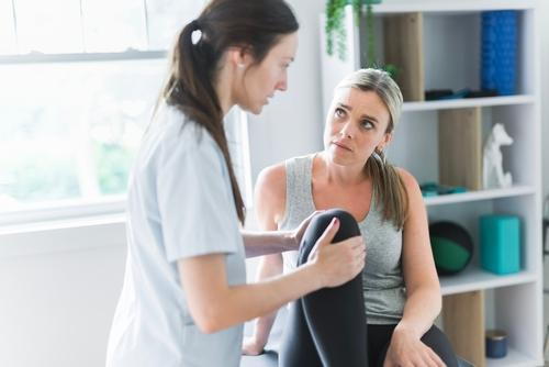 A female patient consulting with a chiropractor during a clinic visit.