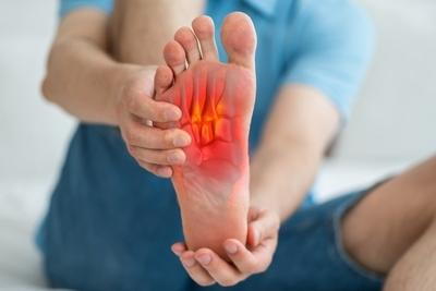 Person holding foot with Plantar Fasciitis in pain