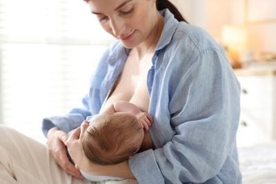 Mother giving a breastfeeding for her baby on bed