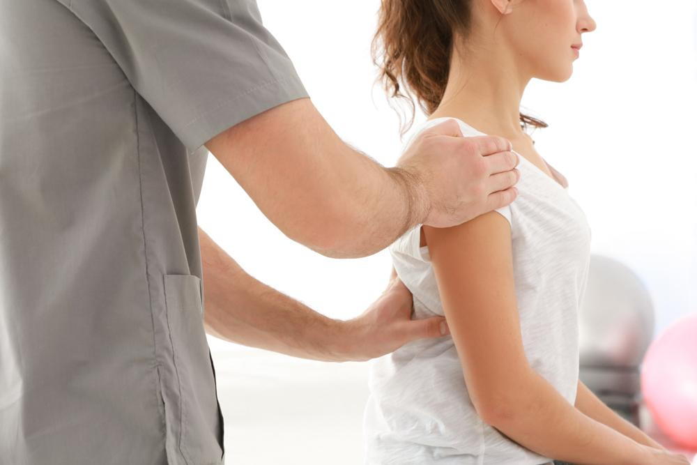Woman getting checked for Scoliosis at her chiropractor.