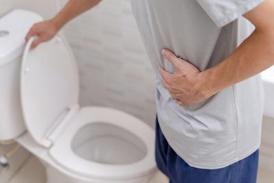 Man-holding-his-belly-opening-the-bowl-in-toilet.