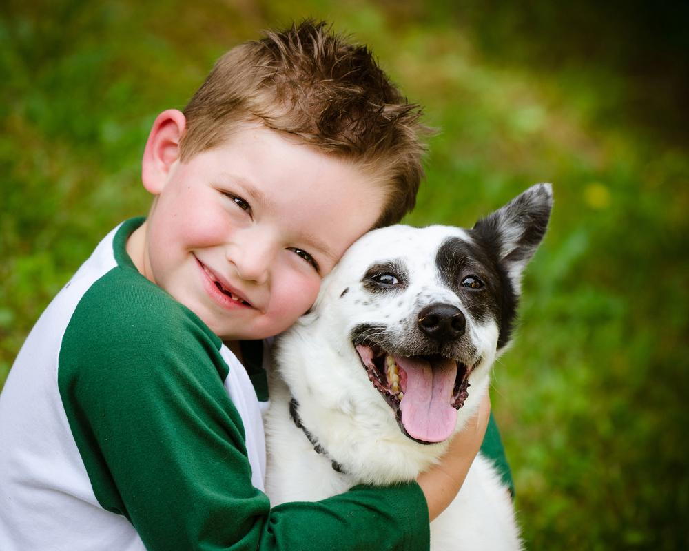 young boy hugging his dog