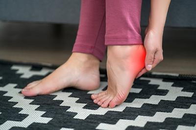 Woman-in-red-pants-holding-her-heel-red-highlights-with-puzzle-floor.