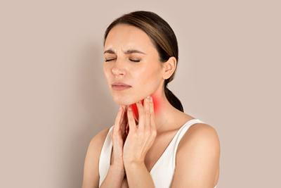 Sick woman holding her throat in pain