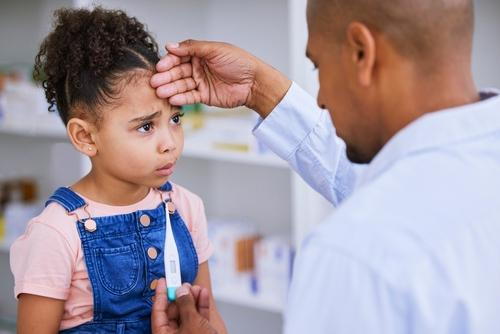 A sick child being examined by a pediatrician during a consultation.