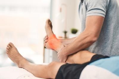 Specialist holding patient’s foot to evaluate pain and foot health issues