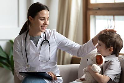Doctor comforting a little boy by patting his head in a clinic visit