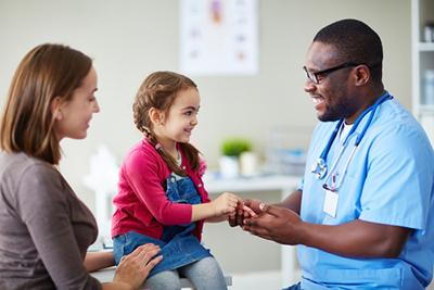 Doctor talking to a young girl with her mother on clinic