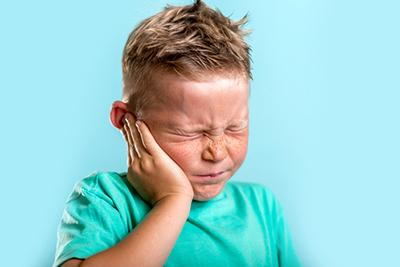 Child experiencing ear pain, showing signs of irritation