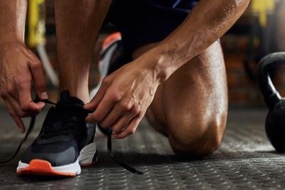 Man tying supportive athletic shoes before workout session