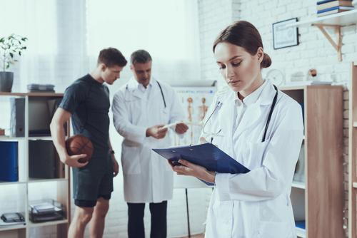 Athlete consulting an orthopedic surgeon while examining imaging results of an injury