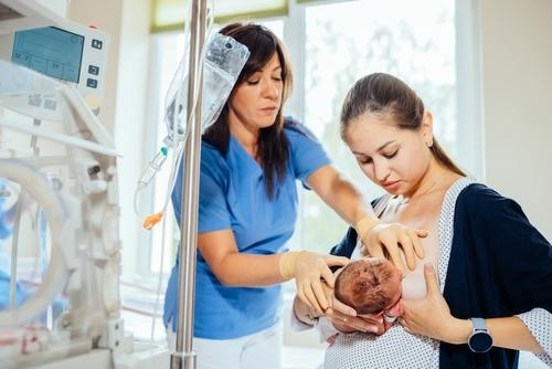 Pediatrician providing lactation support to mother and newborn