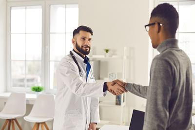Friendly handshake between doctor and walk-in patient.