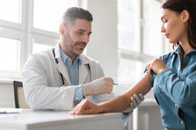 Doctor giving a vaccine to a woman patient.