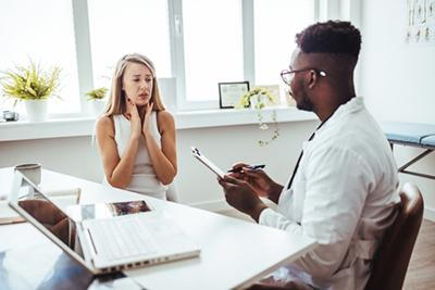 Female patient with throat pain consulting provider at walk-in clinic