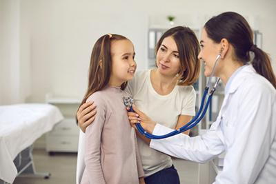 Young girl wither her mother check by the female doctor