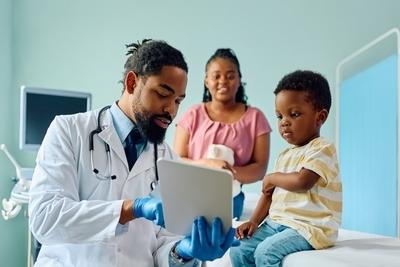 Doctor showing a notes to a young boy with her mother