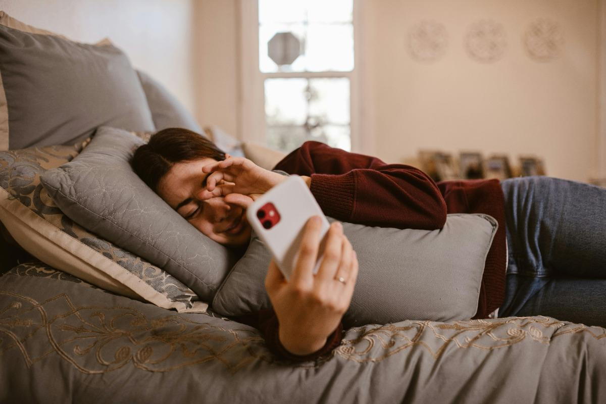 A Woman Using a Smartphone on the Bed