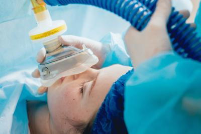 Woman is under general anesthesia with tube of oxygen.