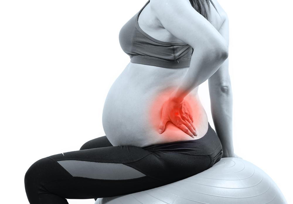 Pregnant woman holding her lower back