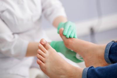Cleaning of diabetic foot on clinic with the doctor on gloves.