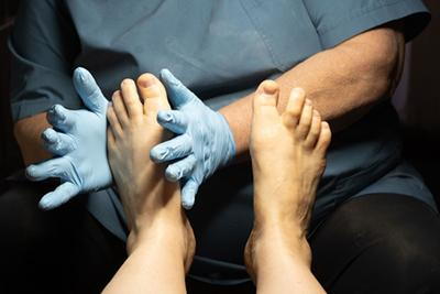 Doctor checking the diabetic foot of patient with gloves