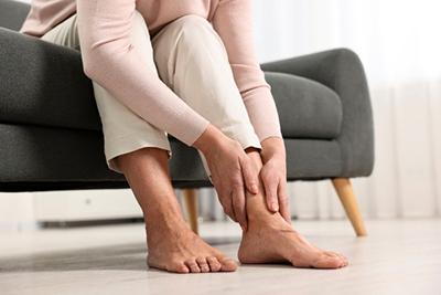 Elderly-Woman-with-Arthritis-Grasping-Her-Feet