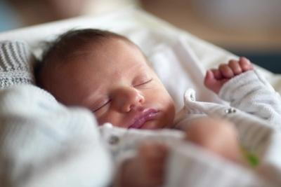 Newborn baby deeply sleeping on bed