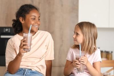 Young girls dringking milk looking each other