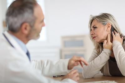Doctor talking to a patient with neck pain.
