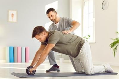 Man guiding an rehabilitation exercise by therapist